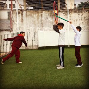 alumnos con pelotas y aros haciendo deporte